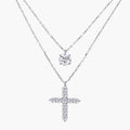 Two delicate sterling silver necklaces with moissanite stones - one solitaire pendant and one cross pendant on white background.