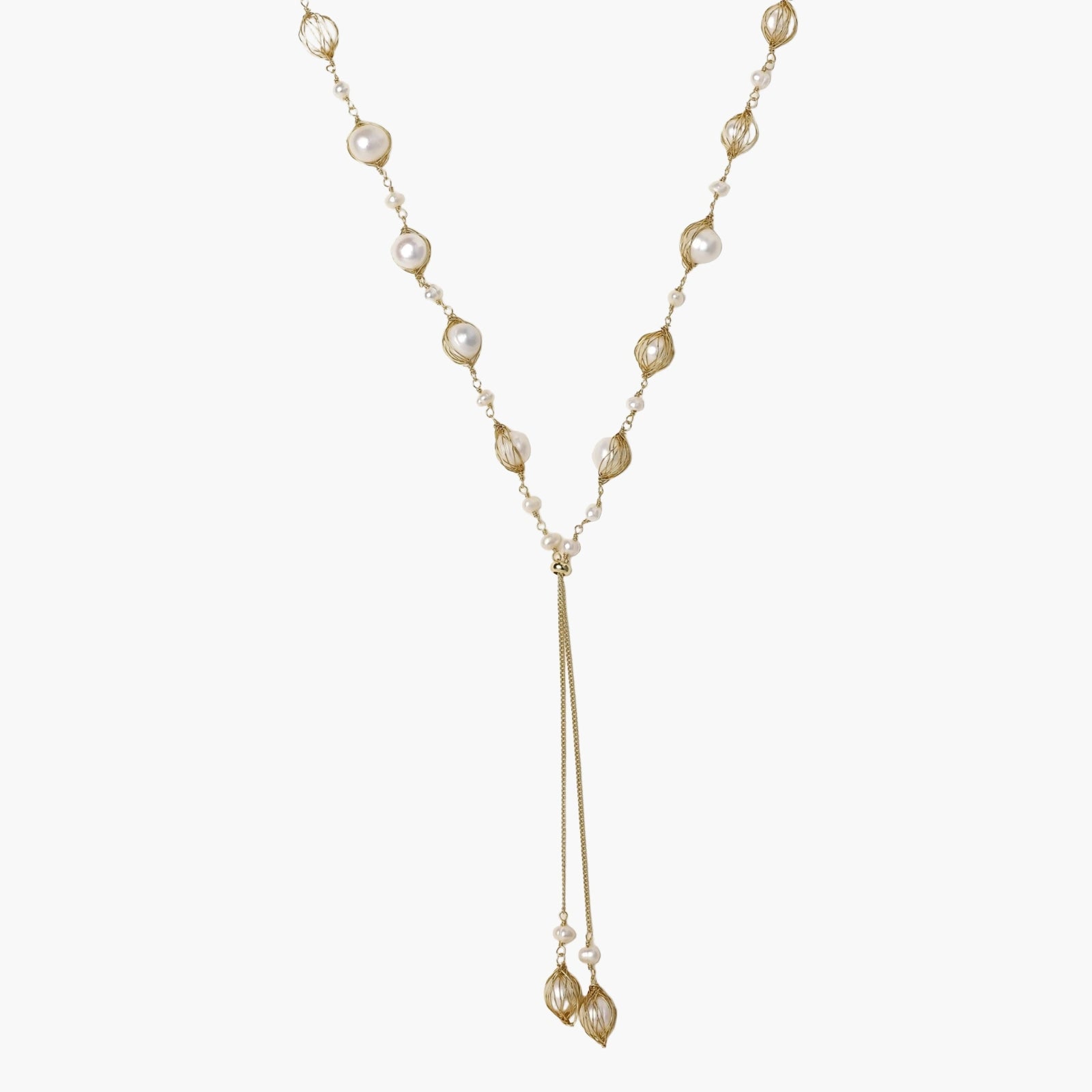 Adjustable gold lariat necklace with freshwater pearls nested in delicate cage settings and Y-shaped tassel drop