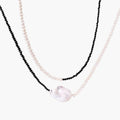 Double-strand necklace with black faceted quartz and white pearls featuring an oversized baroque pearl centerpiece