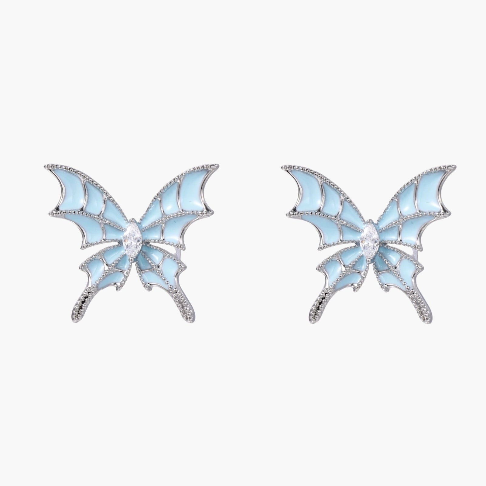 Long silver-tone earrings with powder blue enamel butterfly studs and flowing chain tassels on cream background