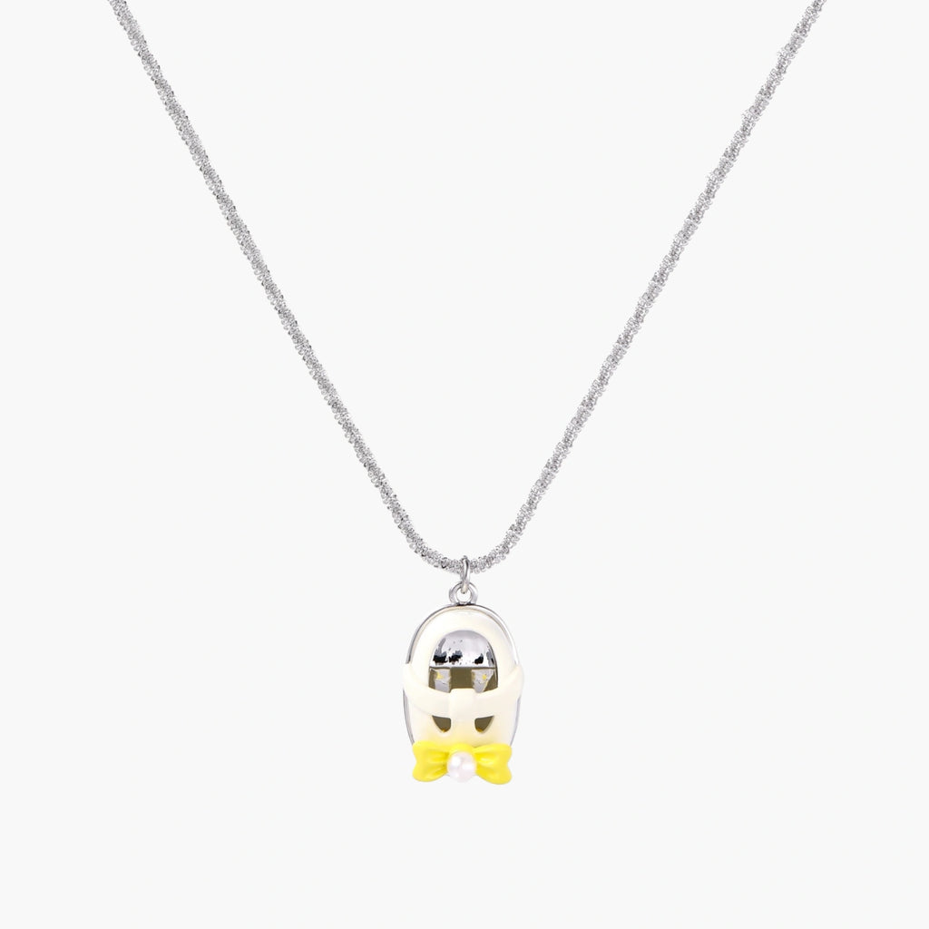 Chrome egg-shaped pendant with kawaii face, yellow bow, and pearl detail on silver chain against white background