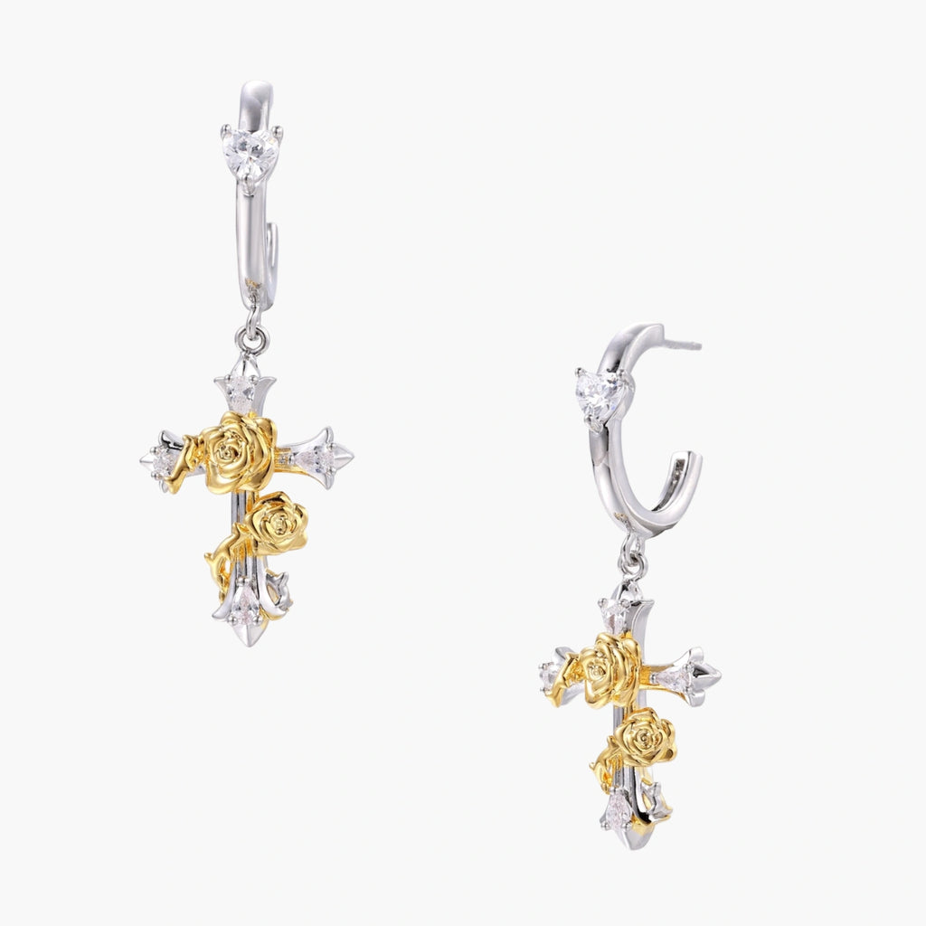 Two-tone huggie hoops with gold rose crosses and star zirconia accents on cream background