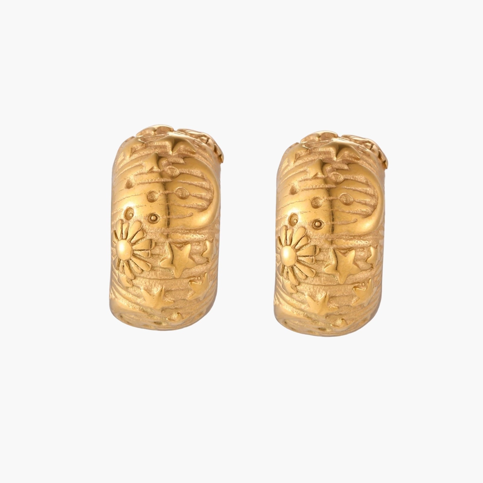 Wide gold hoop earrings with embossed stars and sun motifs on cream background, showing dimensional relief details.