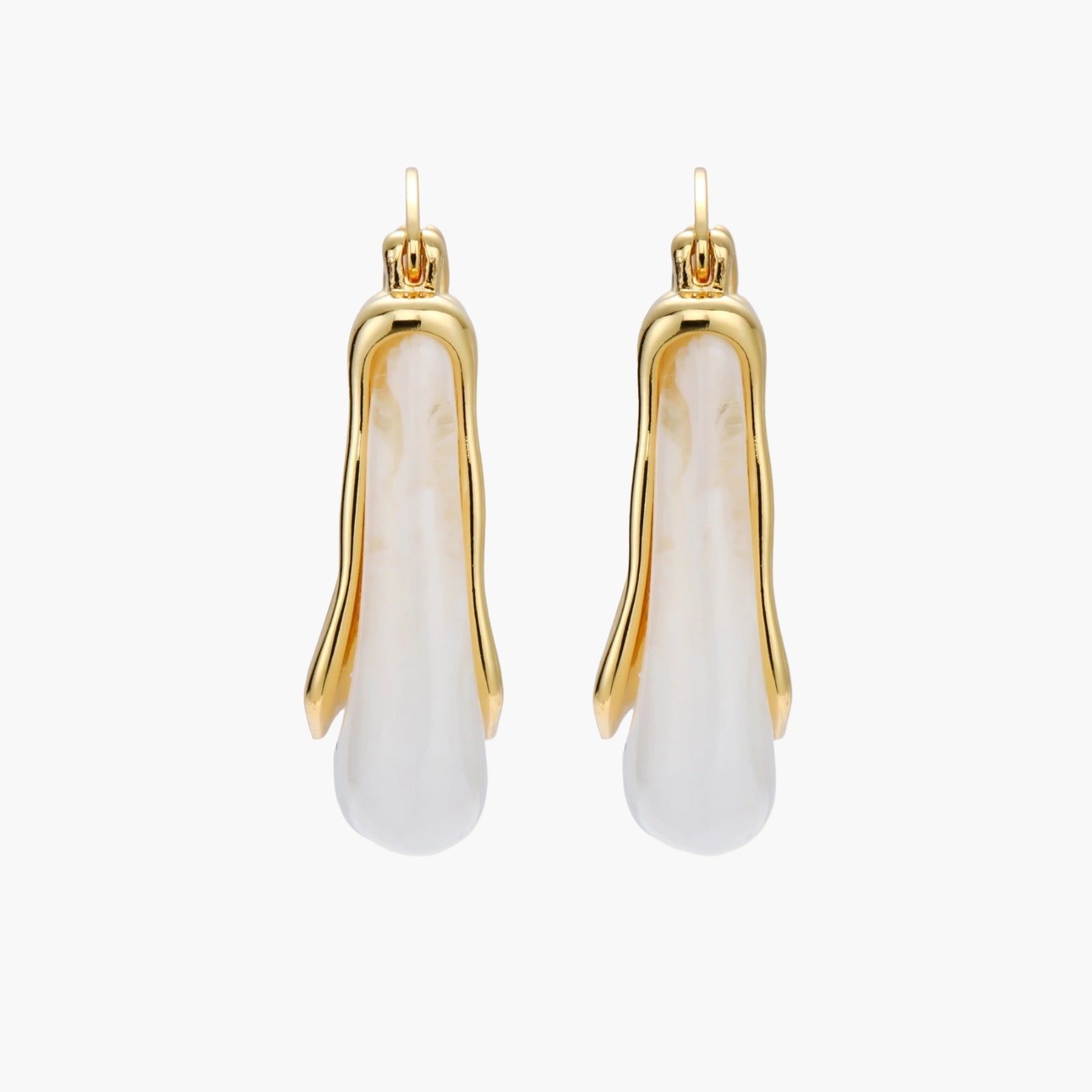 Sculptural gold-plated hoop earrings with flowing curved design and lever-back closure on cream background.